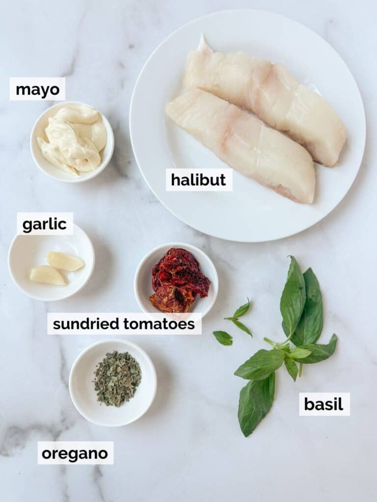 Ingredients for baked halibut on a marble background.