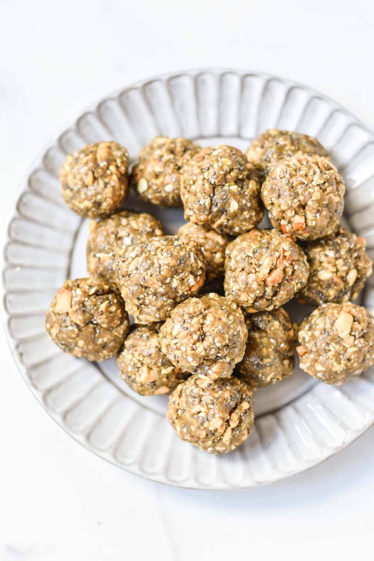 Stacked oatmeal energy balls on a scalloped edge plate.