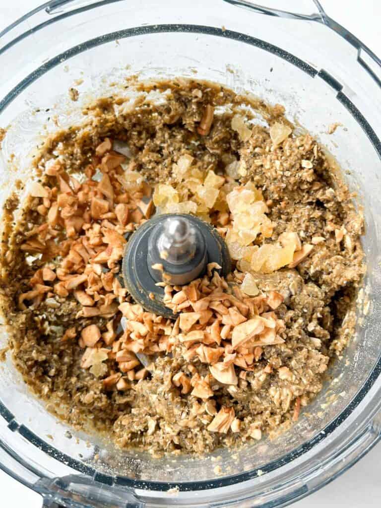 Adding in ginger and dried apples to the protein ball dough mix.