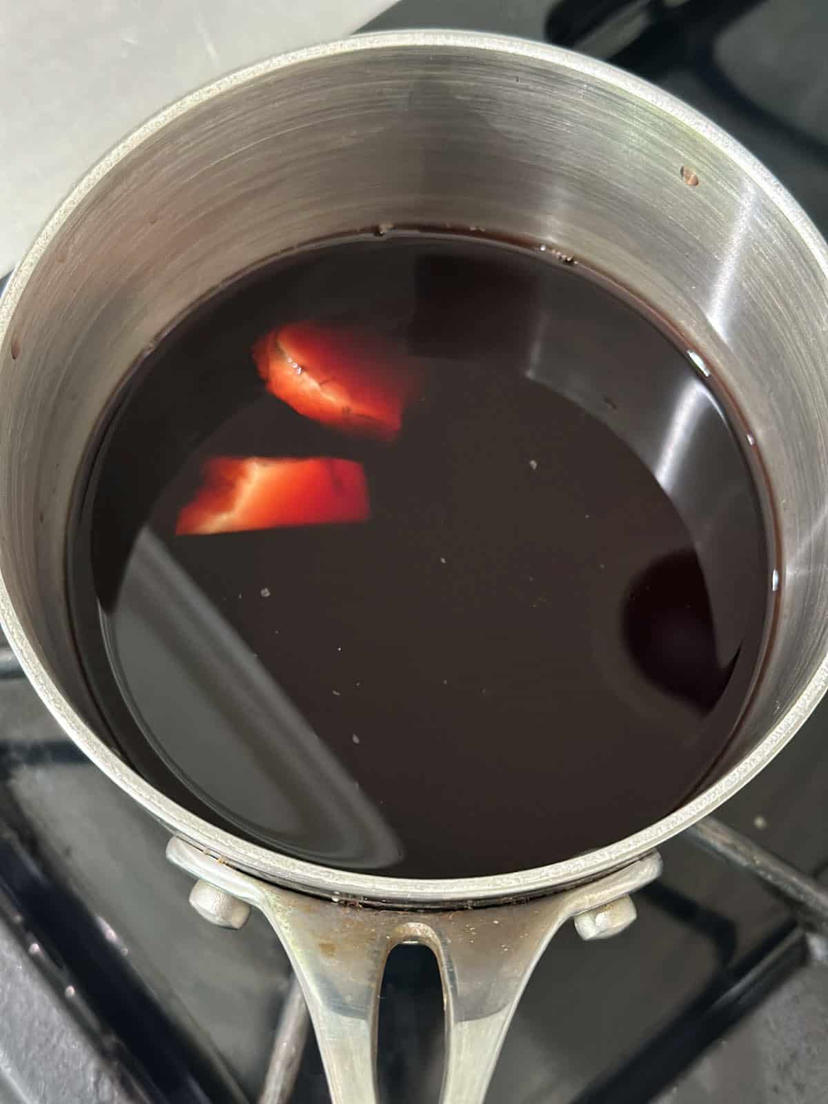 Simmering ginger with tart cherry juice and chamomile in a small pot.