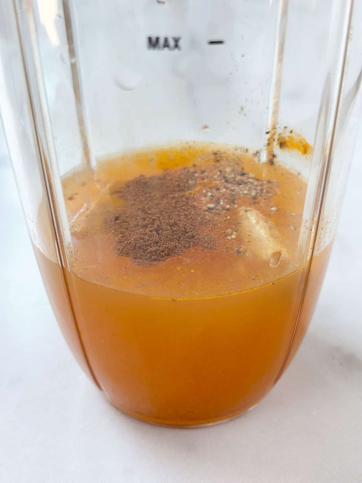 A blender filled with apple juice and spices.