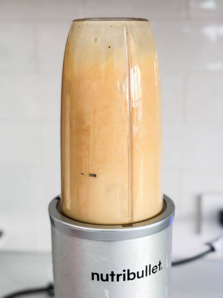 Blending apple cider with spices in a high speed blender.