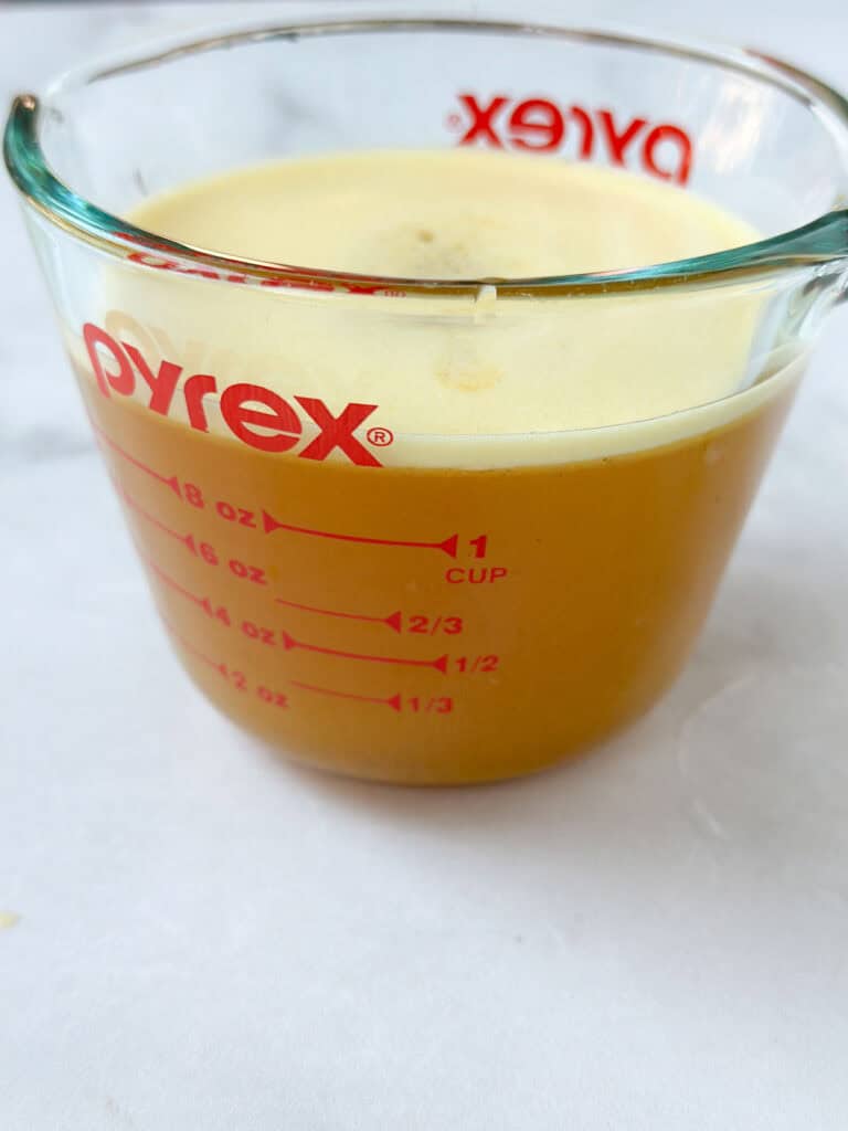 A large glass filled with the strained apple cider mixture.