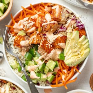 Salmon rice bowls topped with spicy mayo and sesame seeds.