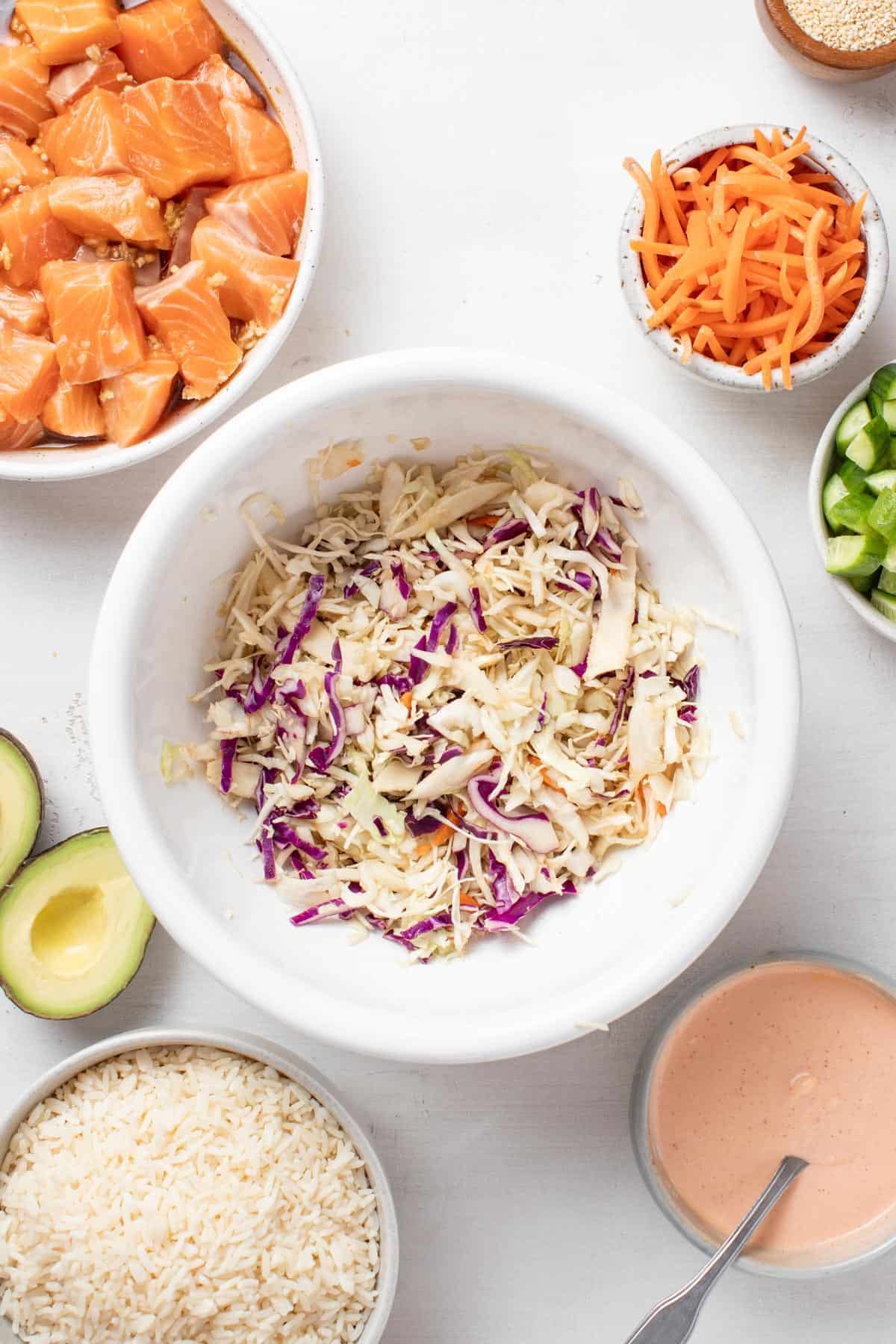 Slaw tossed in vinegar and coconut aminos in a small white bowl.