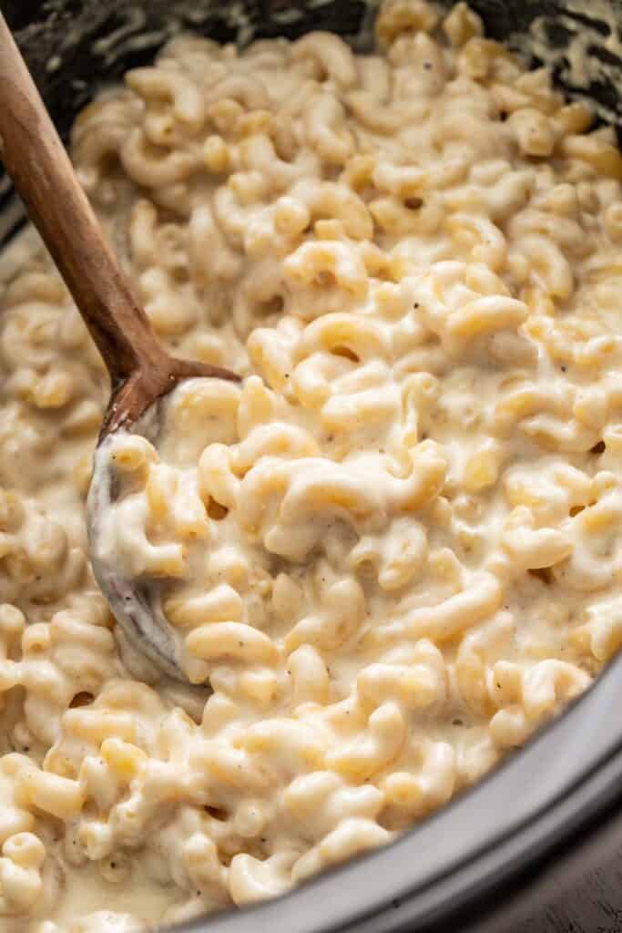 A spoon scooping up a white mac and cheese.