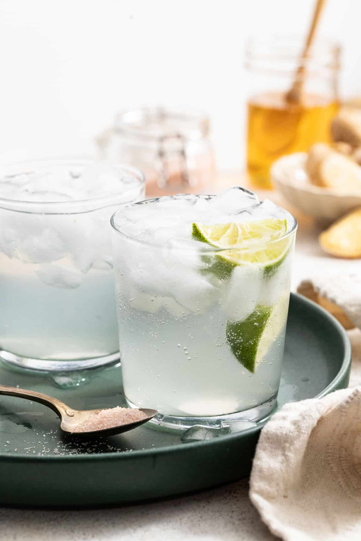 Two electrolyte drinks filled with ice and sliced limes.