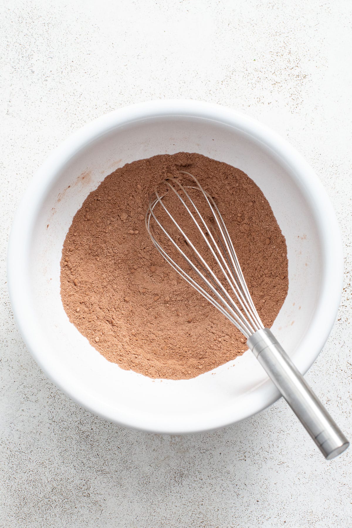 Stirring together the dry ingredients in a bowl with a whisk.
