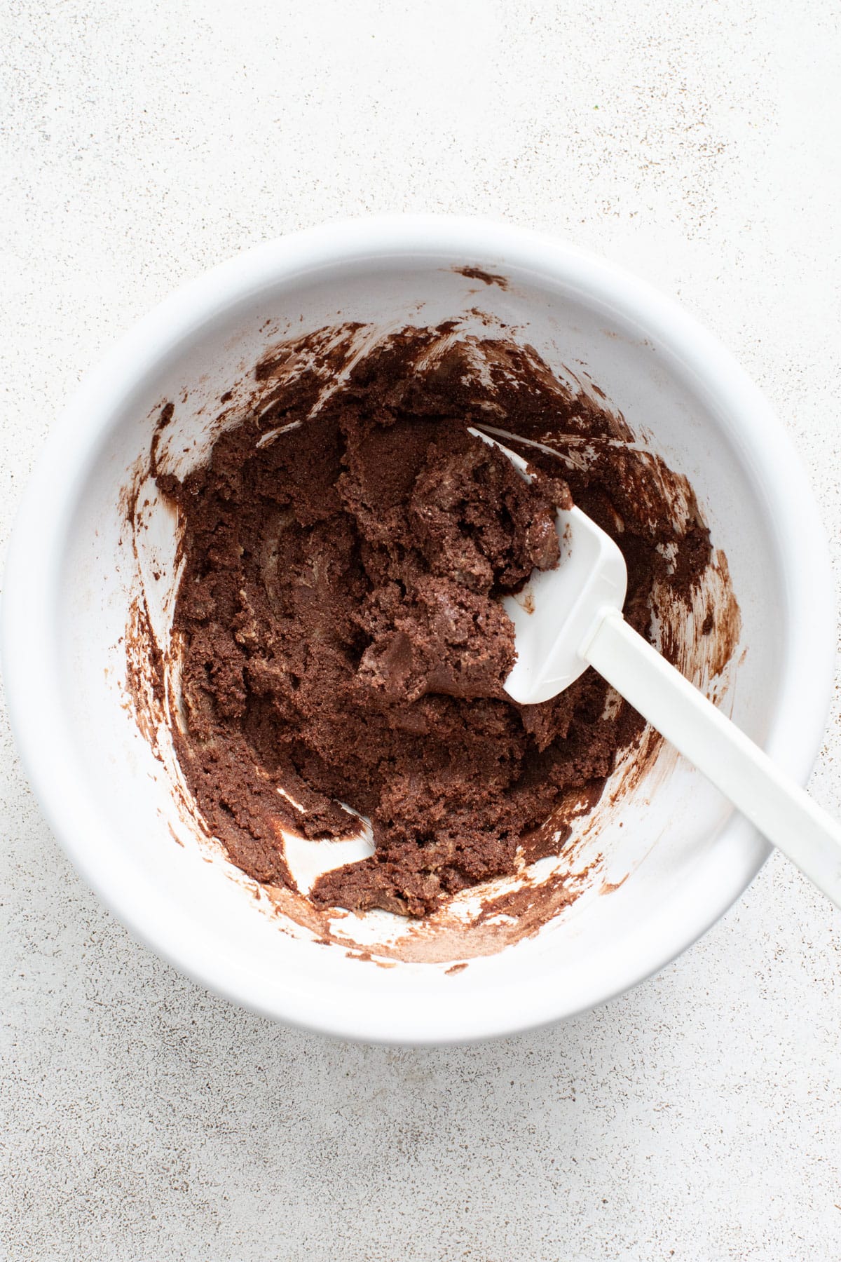 Mixing together the brownie dough with a spatula.