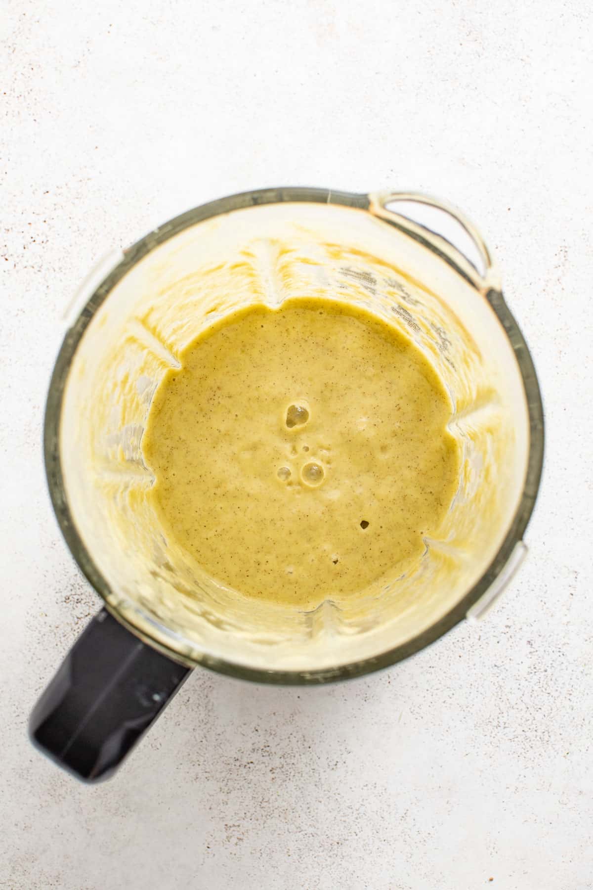 Mango and ginger in a blender after blending together to create a smoothie.