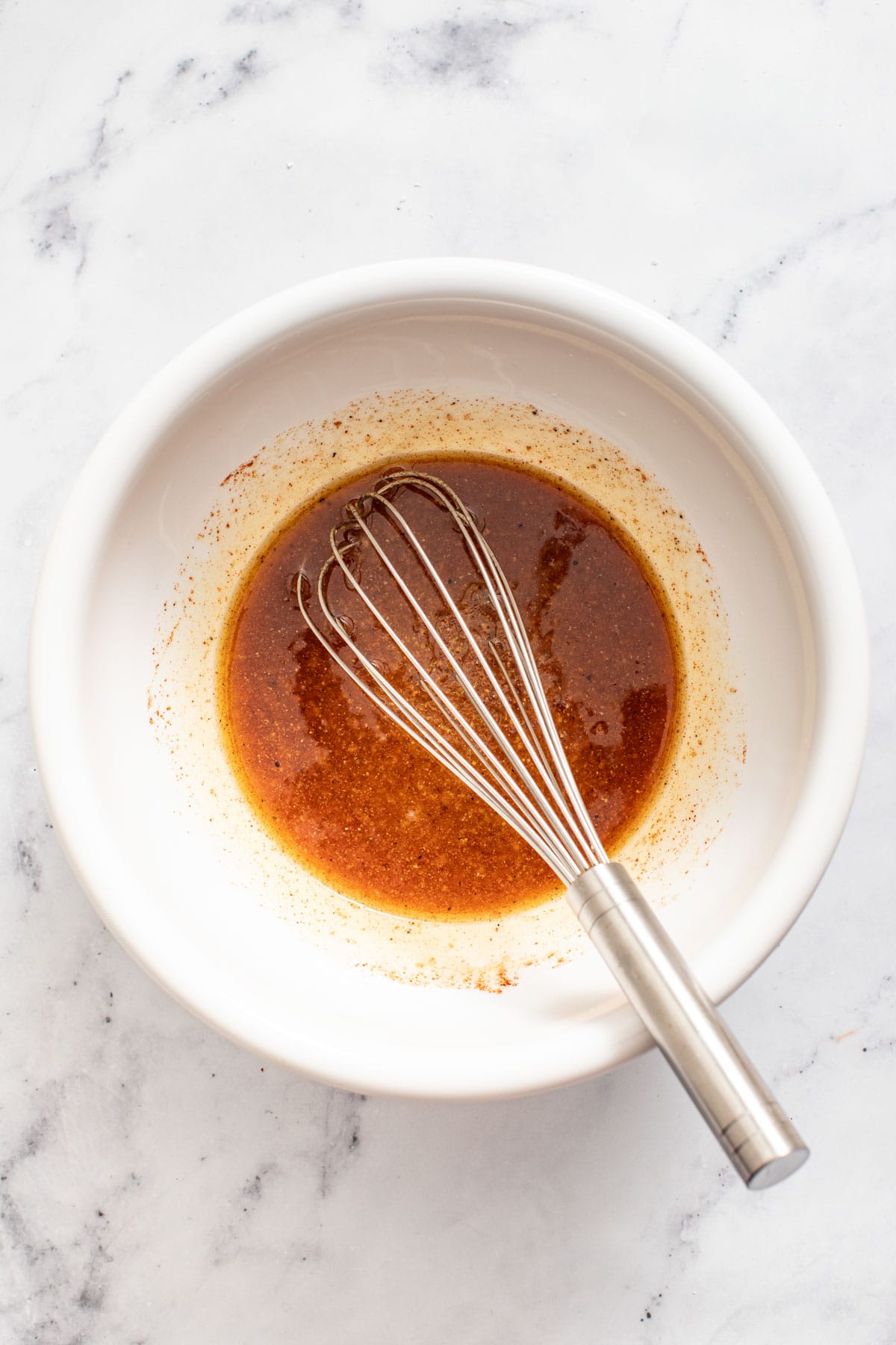 A bowl with the maple djion sauce whisked till smooth.