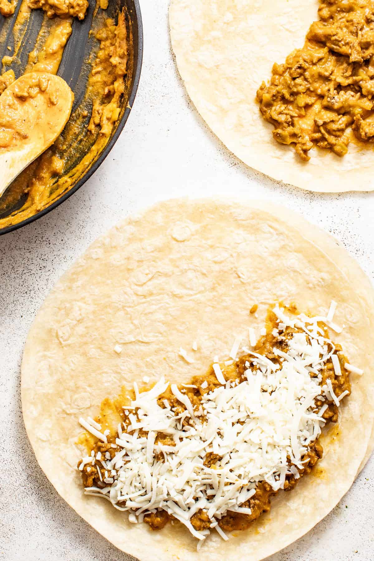 Ground beef and cheese on half of a quesadilla before baking.