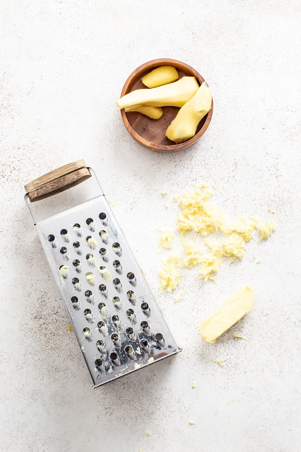 Grating fresh ginger on a cheese grater.