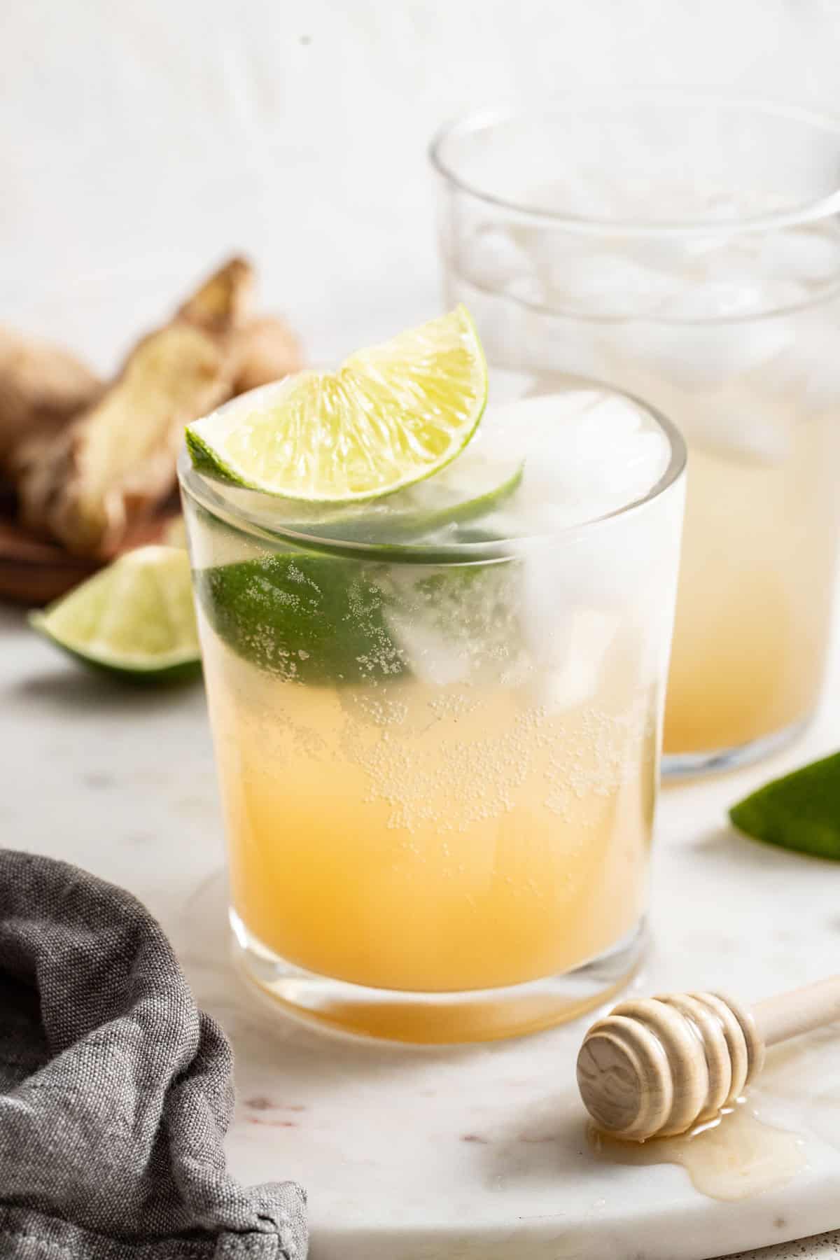 A glass filled with homemade ginger ale and lime slices.