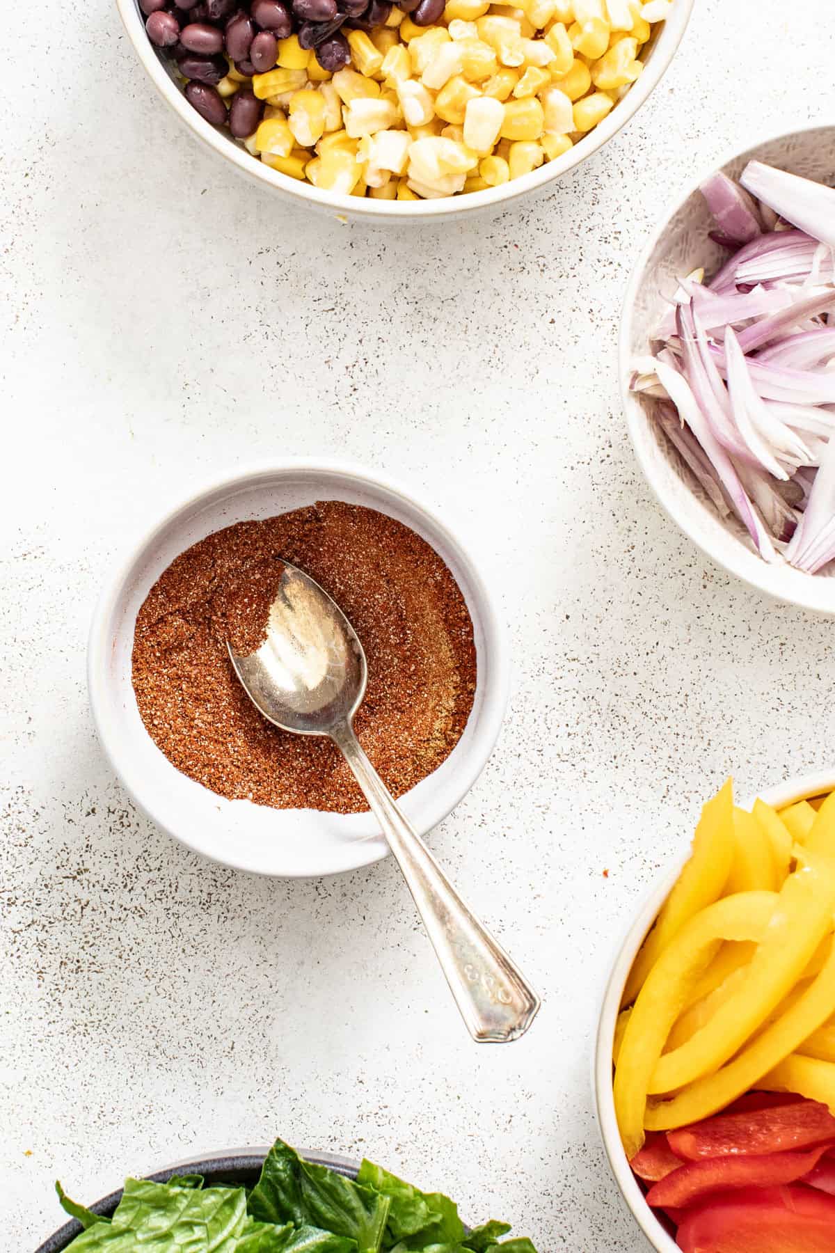 Seasoning for chicken fajitas all mixed together in a small white bowl.