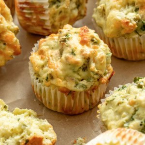A cheesy muffin with vegetables on a sheet pan.