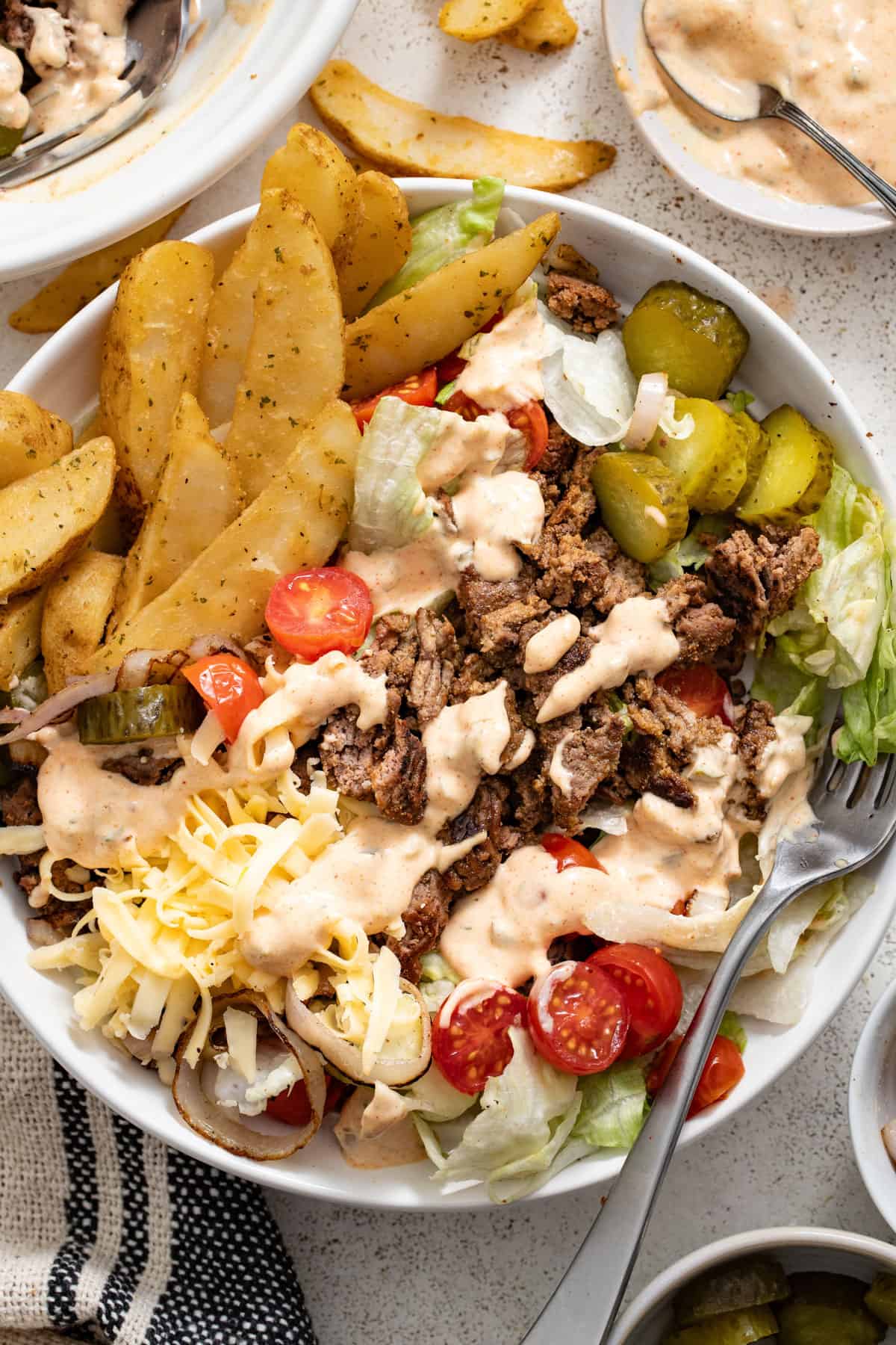 A picture showing french fries next to the burger salad bowl for a pairing suggestion.