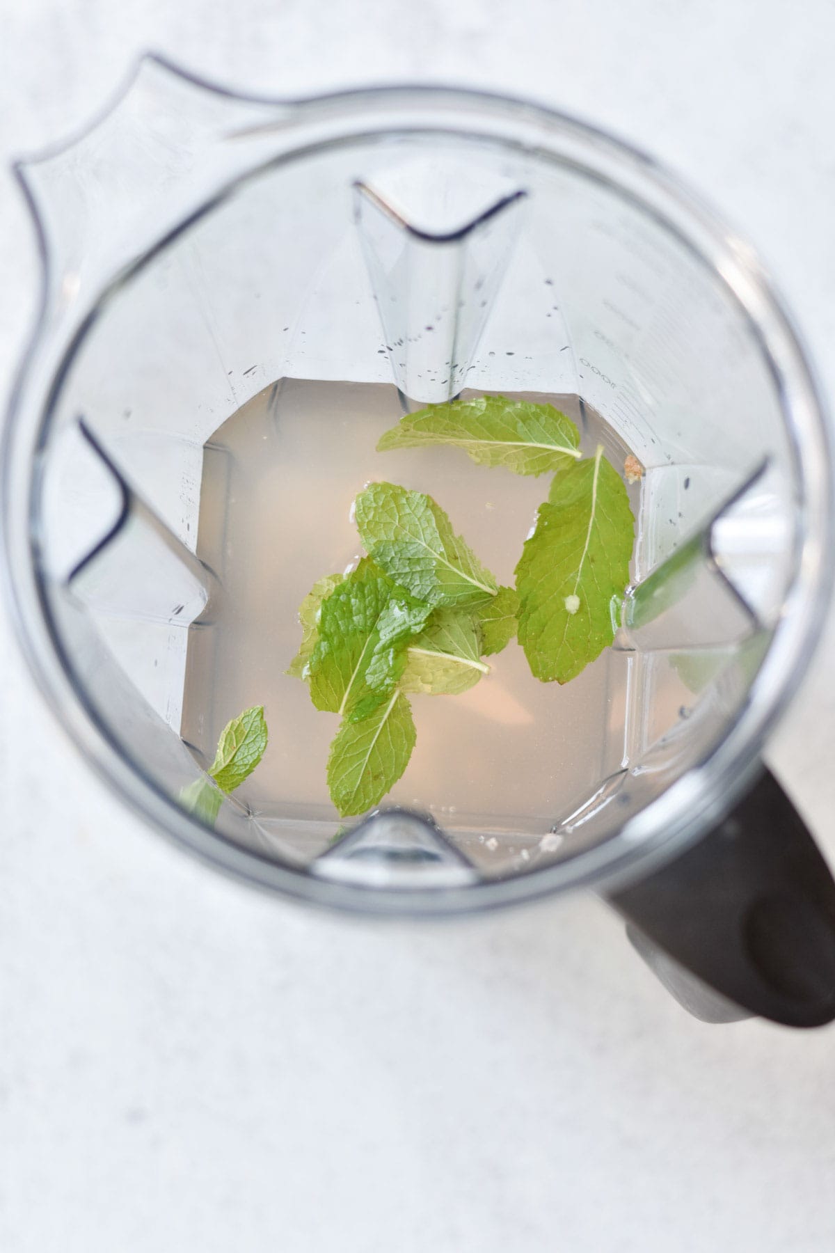 Coconut water, mint, and ginger in a blender.