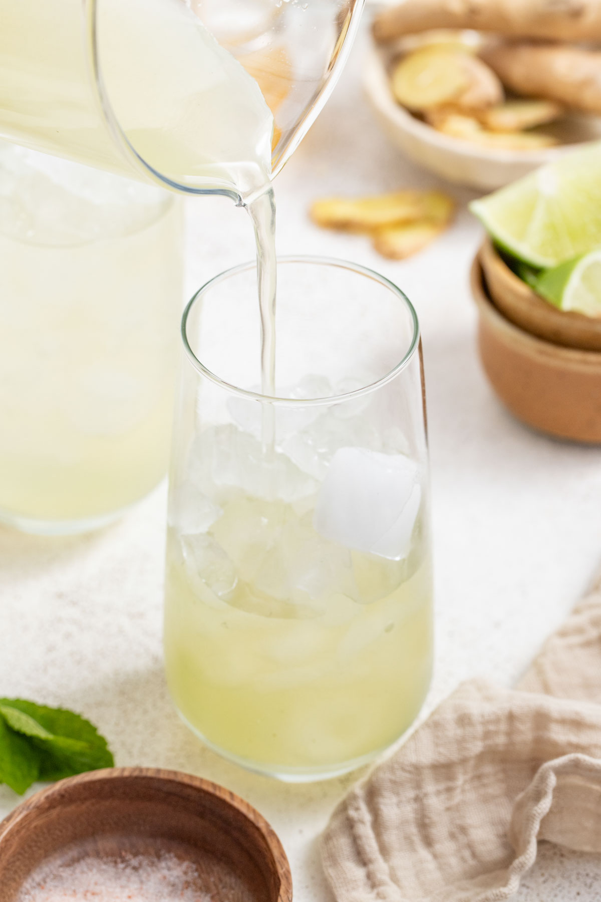 Pouring the ginger base of the drink into a glass with ice.