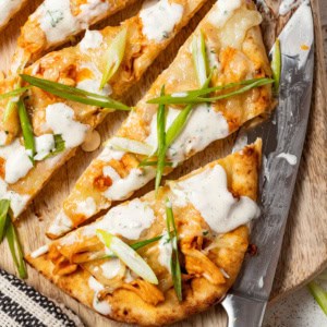Buffalo chicken flatbread on a cutting board.