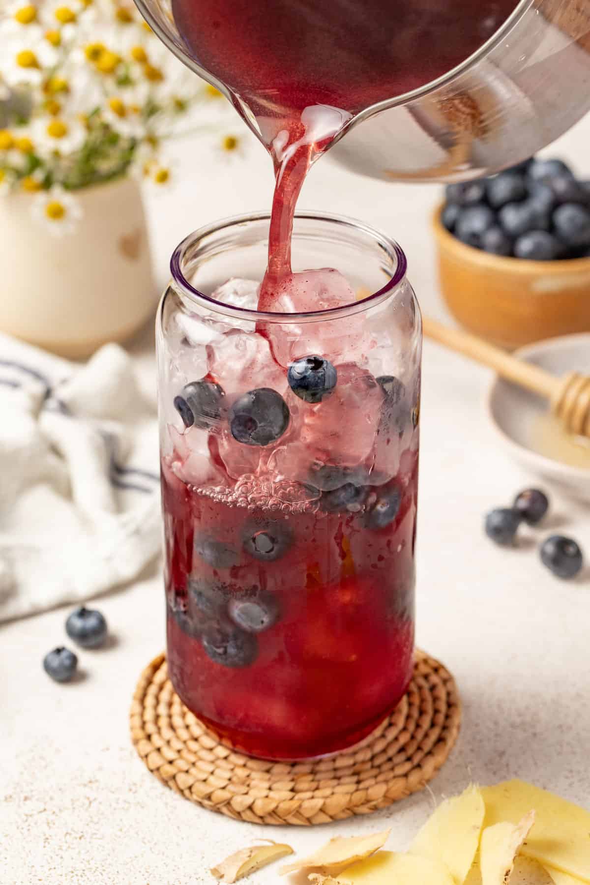 Pouring the blueberry tea over ice.