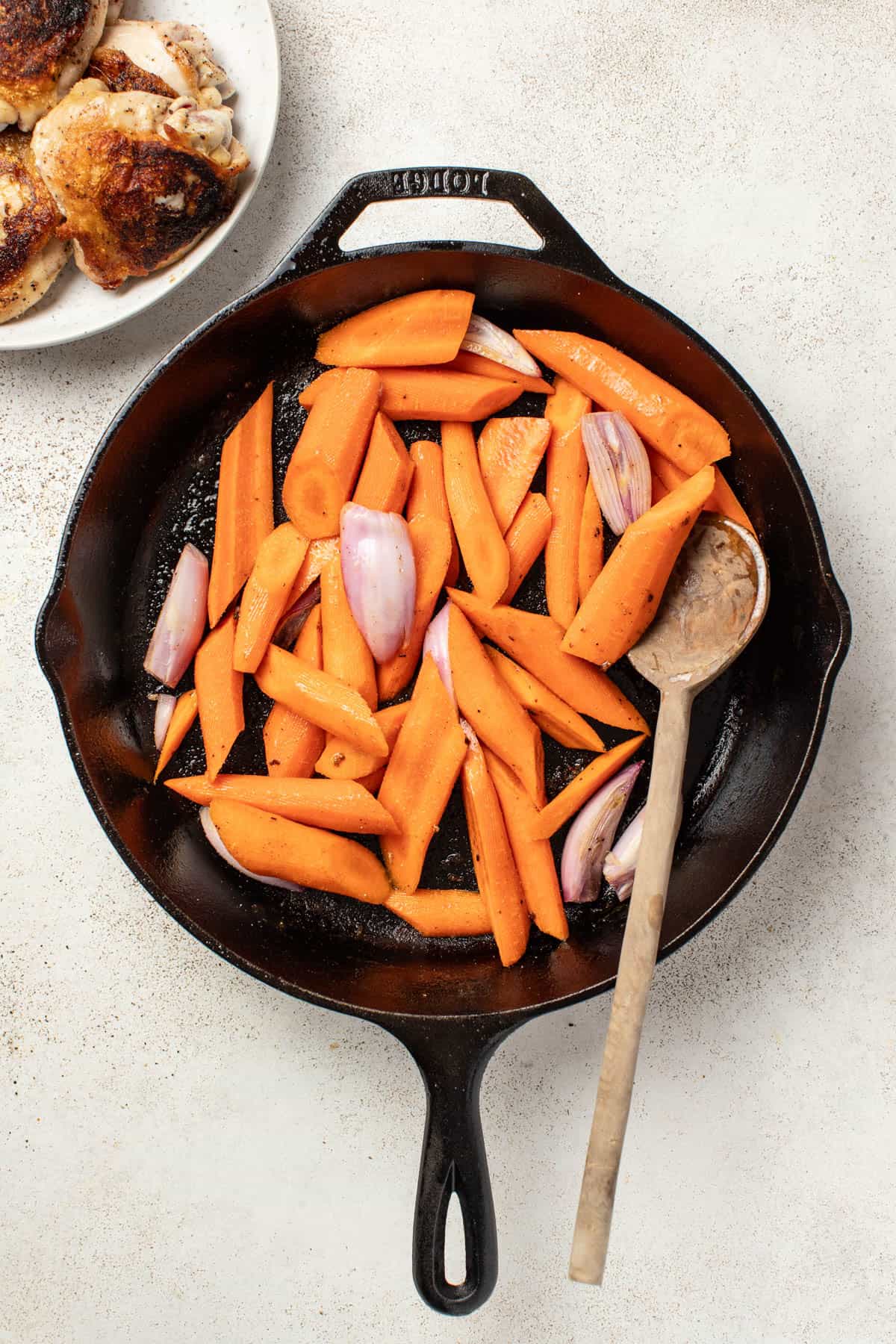 Cooking carrots and shallots in a cast iron pan.