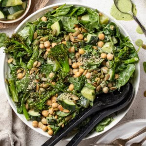 Spinach salad with chickpeas and cucumbers tossed in a creamy dressing.
