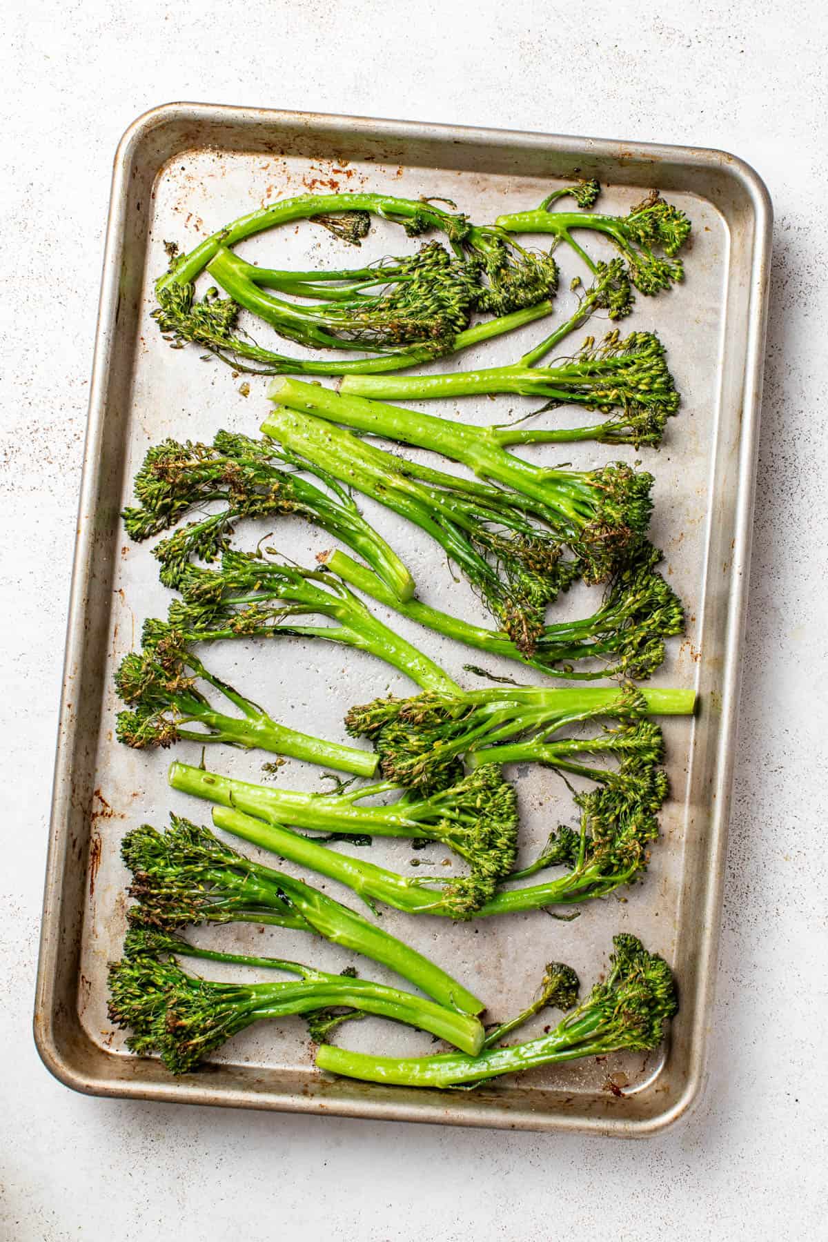 Broccolini on a roasting pan after roasting.