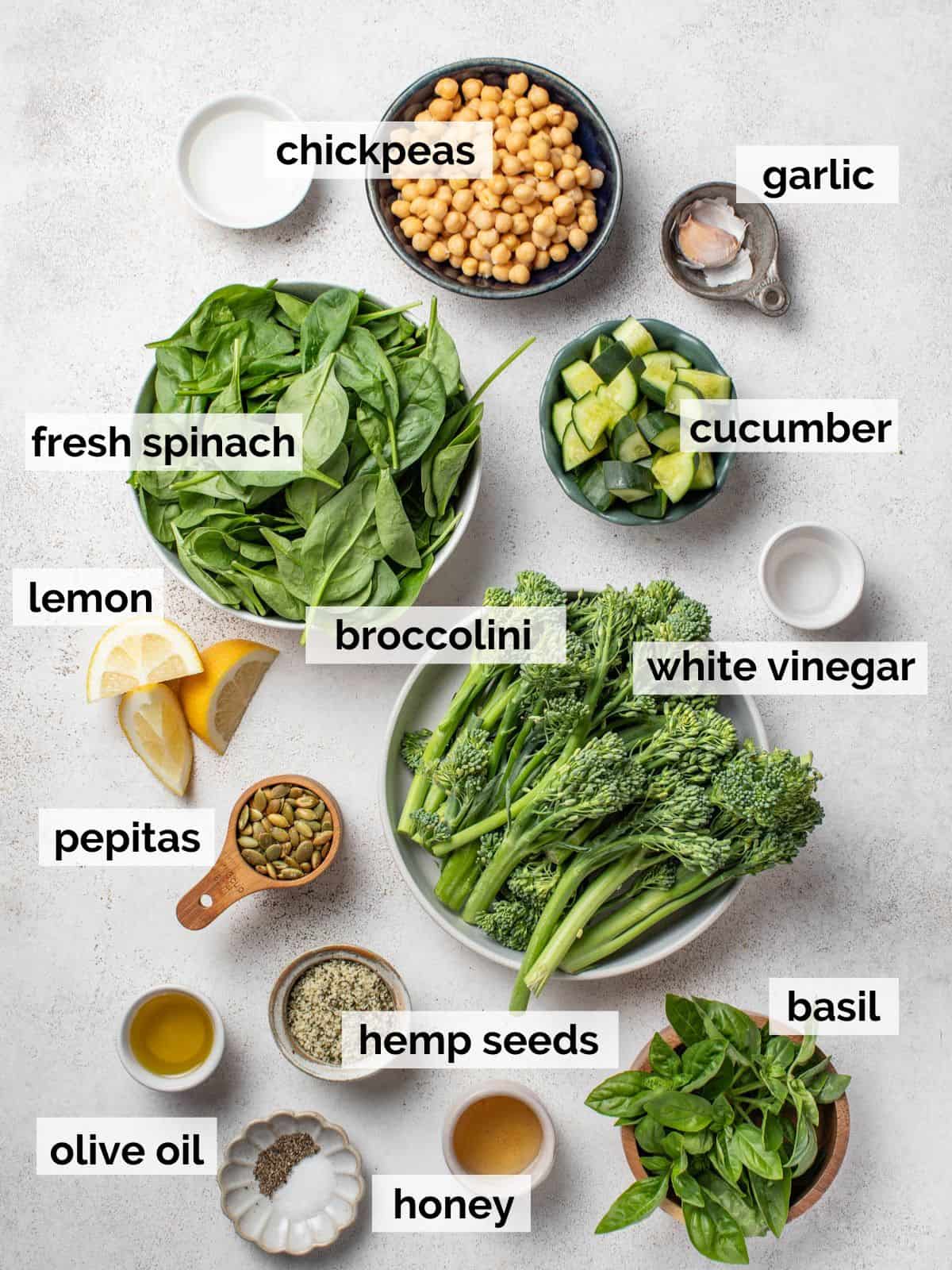 ngredients for a spinach salad with chickpeas, cucumber, and seeds.