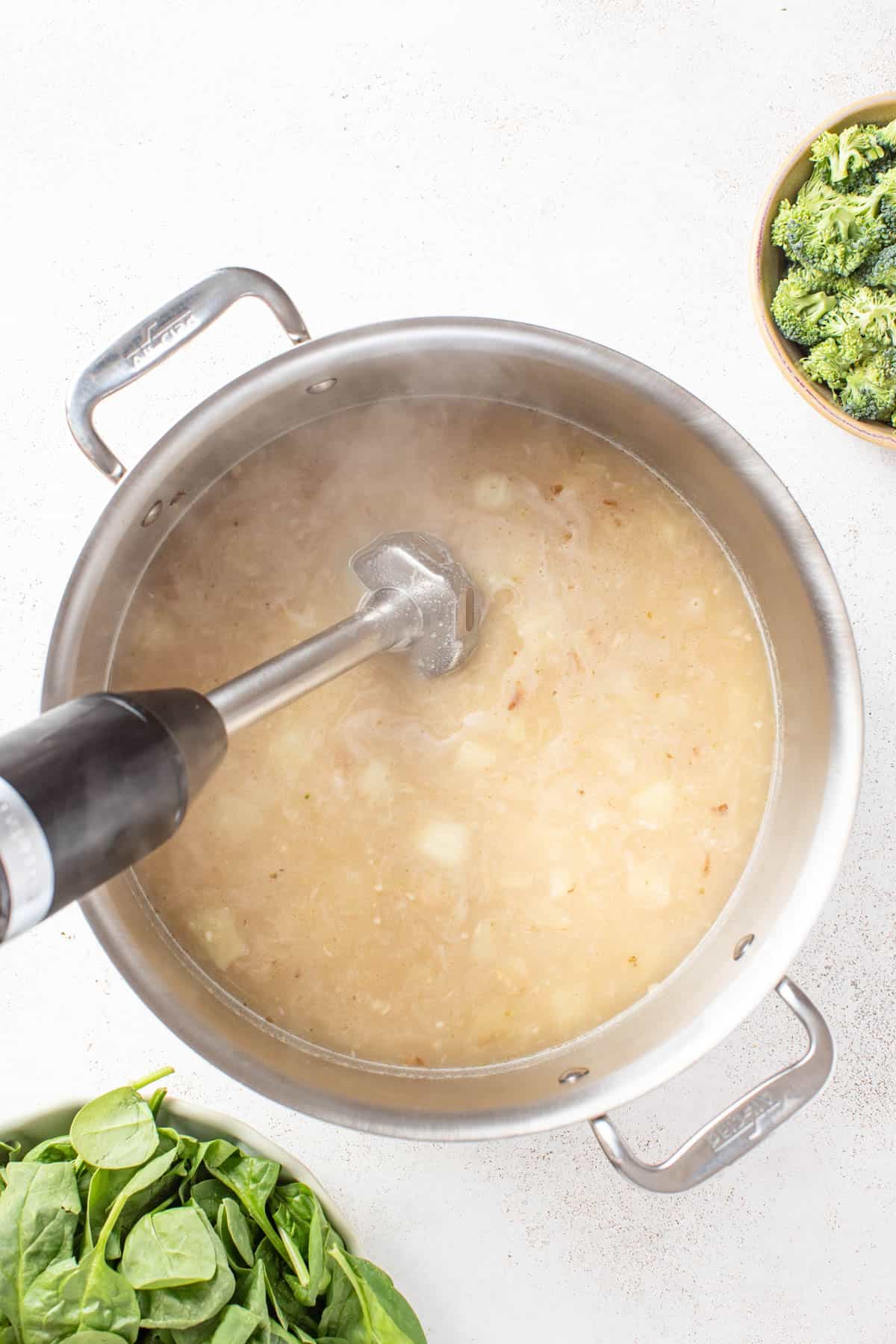 Blending the white beans and potatoes in the soup to make a creamy texture.