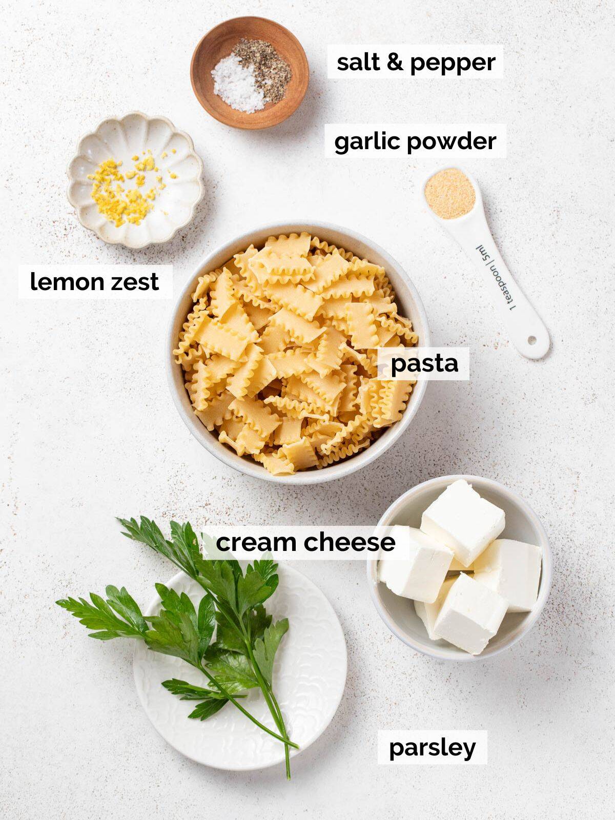 Ingredients for cream cheese pasta on a white background.