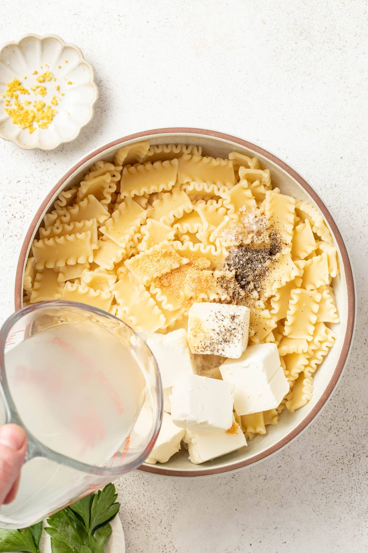 Adding pasta water to the pasta with the cream cheese.