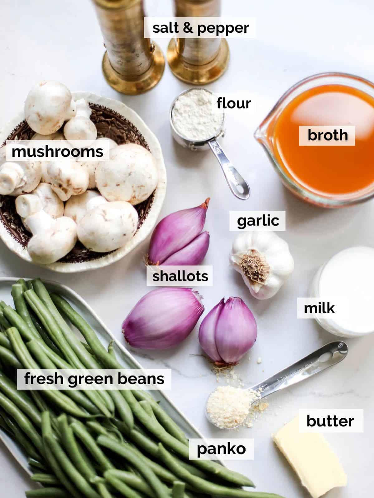 Ingredients for a green bean casserole including, broth, fresh green beans, milk for the sauce, and shallots.
