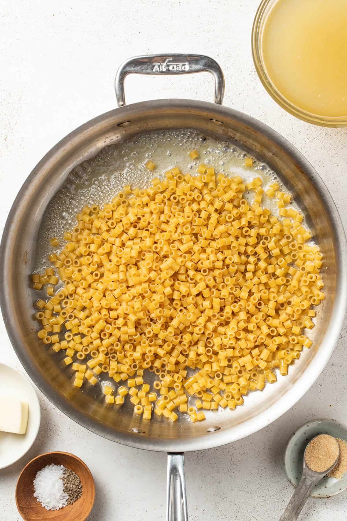 Ditalini pasta and butter in a skillet.