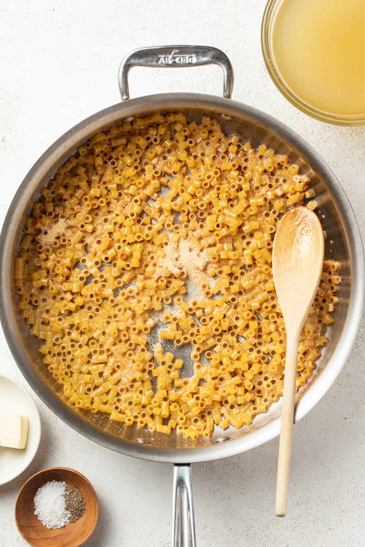 Adding garlic powder to the butter and pasta.