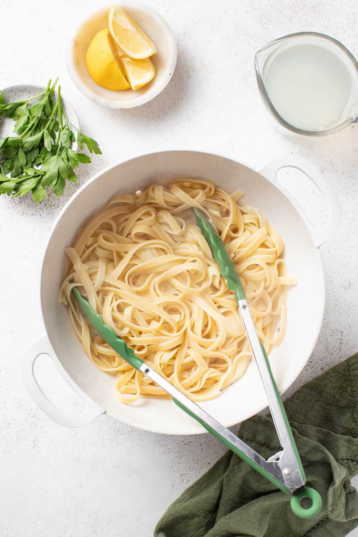 Draining the pasta and reserving a cup of the pasta water to the side.