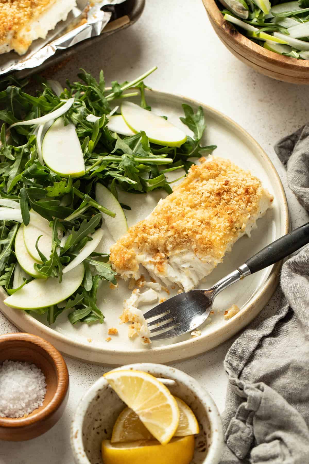 Halibut next to a side salad with apples and fennel.