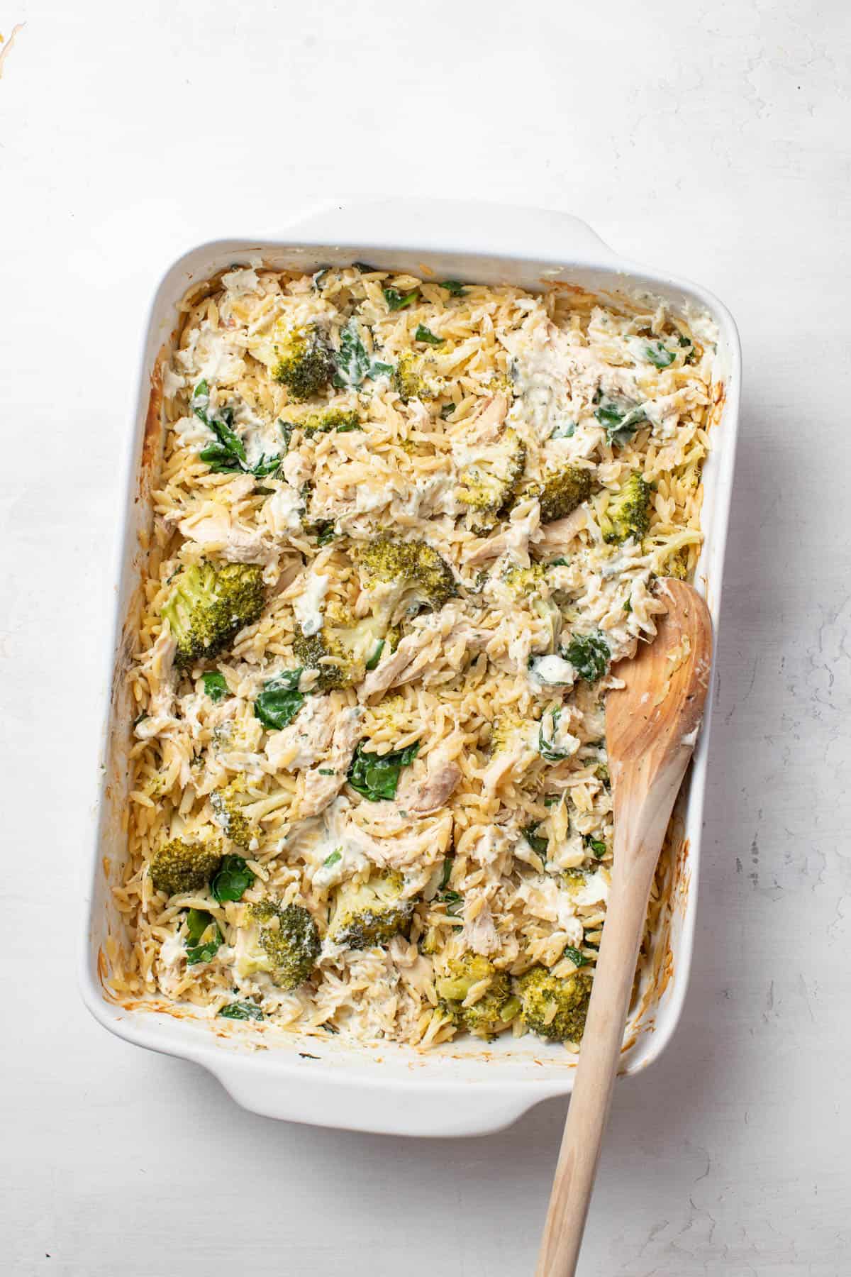 Stirring the baked orzo with a wood spoon.