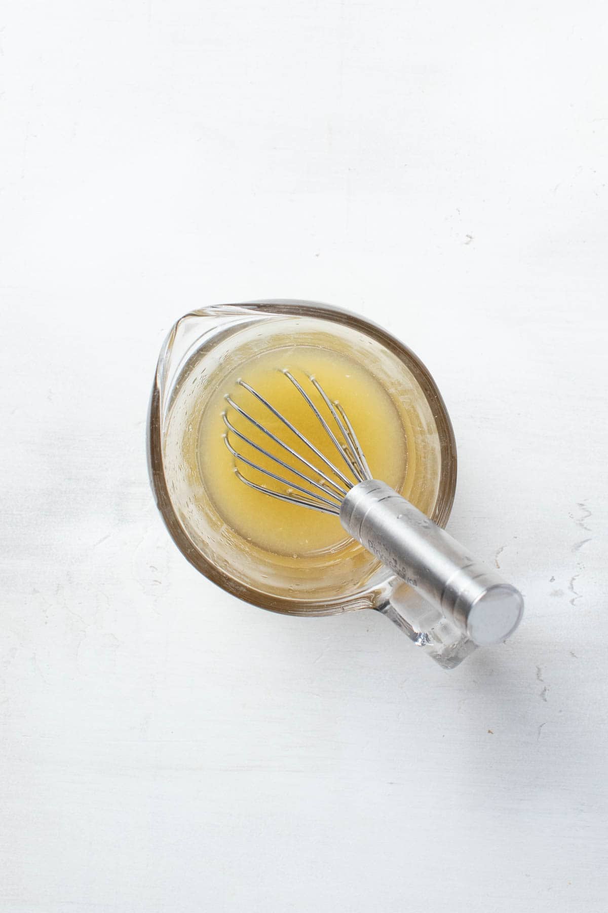 Whisking together lemon and lime juice with sweetener.