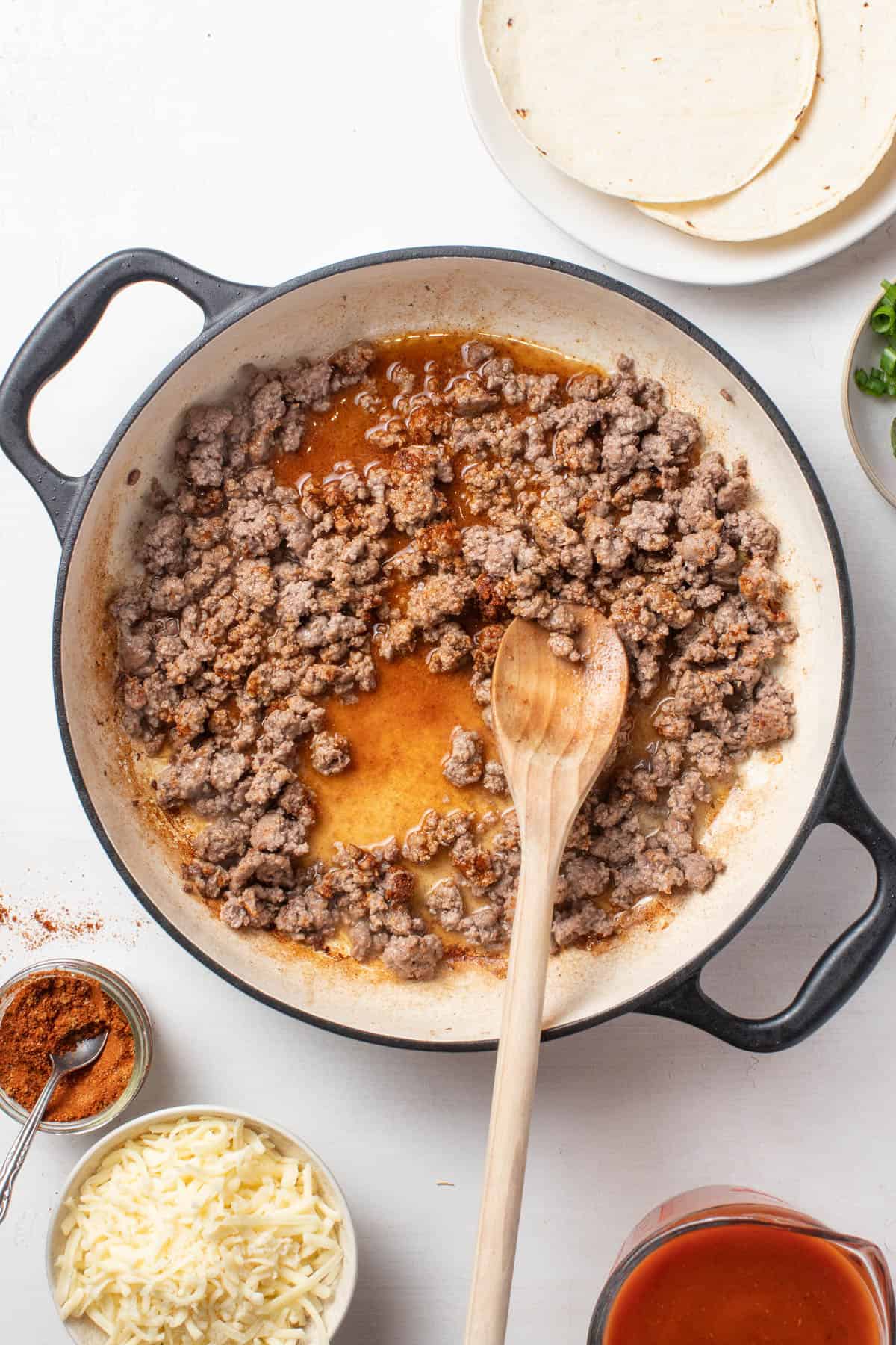 Adding taco seasoning to the ground beef.