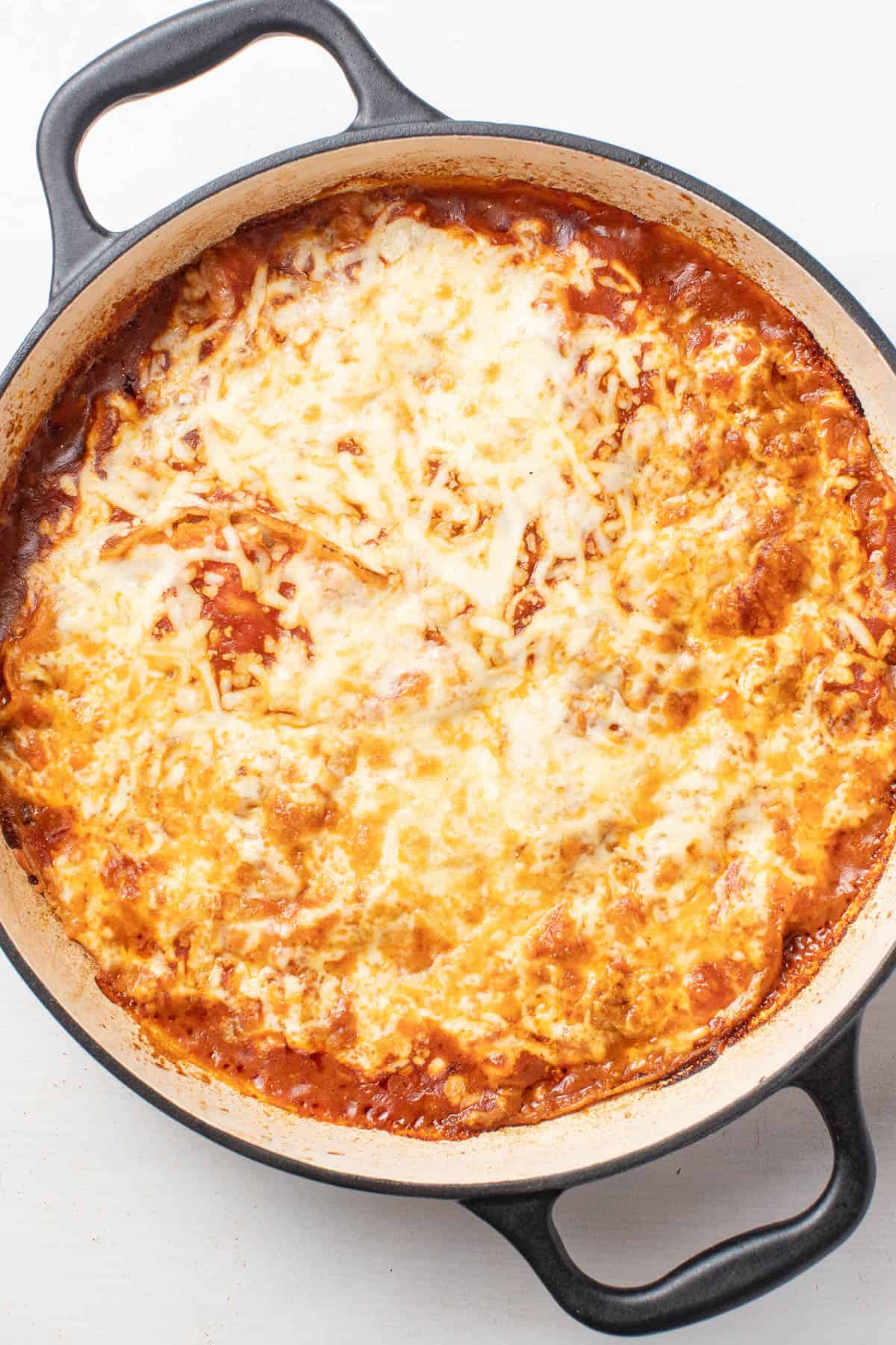 The baked enchilada skillet with melted cheese on top.