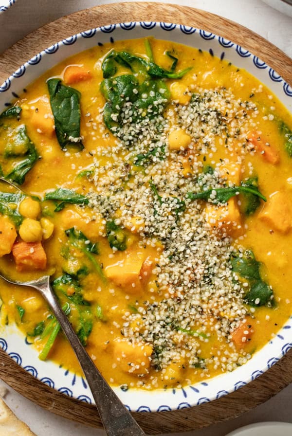Turmeric chickpea stew in a bowl topped with hemp seeds.