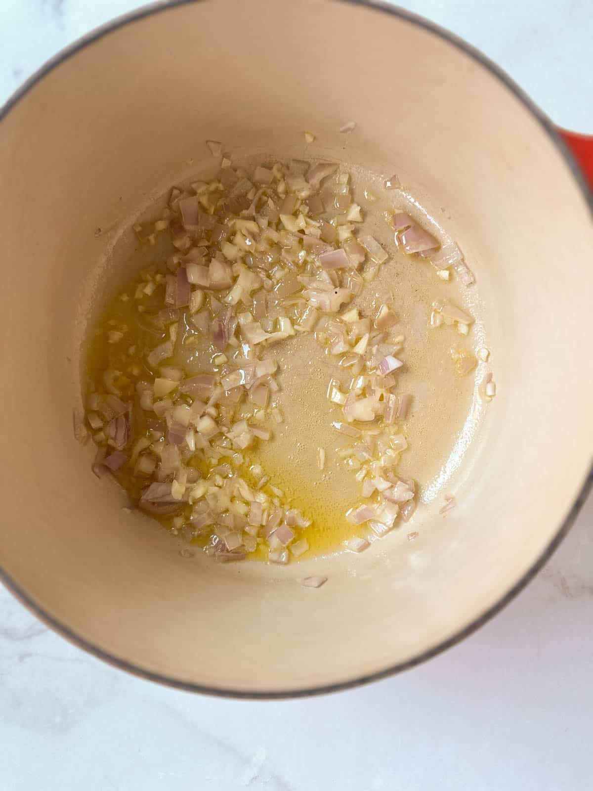 Shallots and garlic in a dutch oven with melted butter.