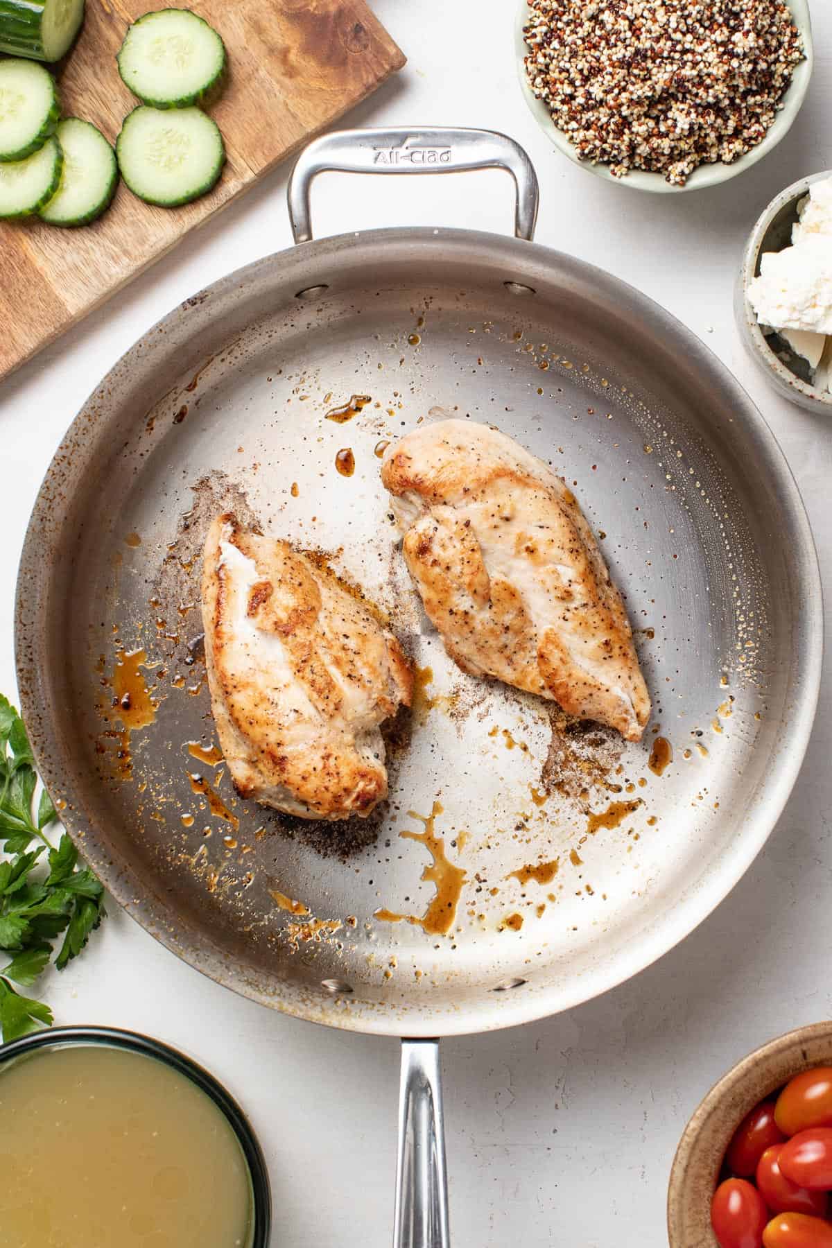 Searing chicken breasts in a pan.