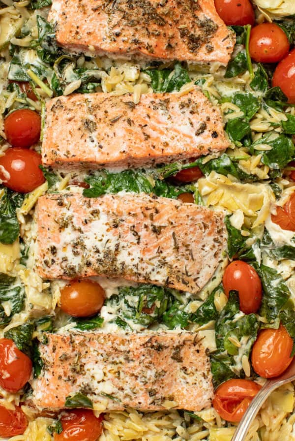 A Mediterranean salmon orzo bake in a white casserole dish.
