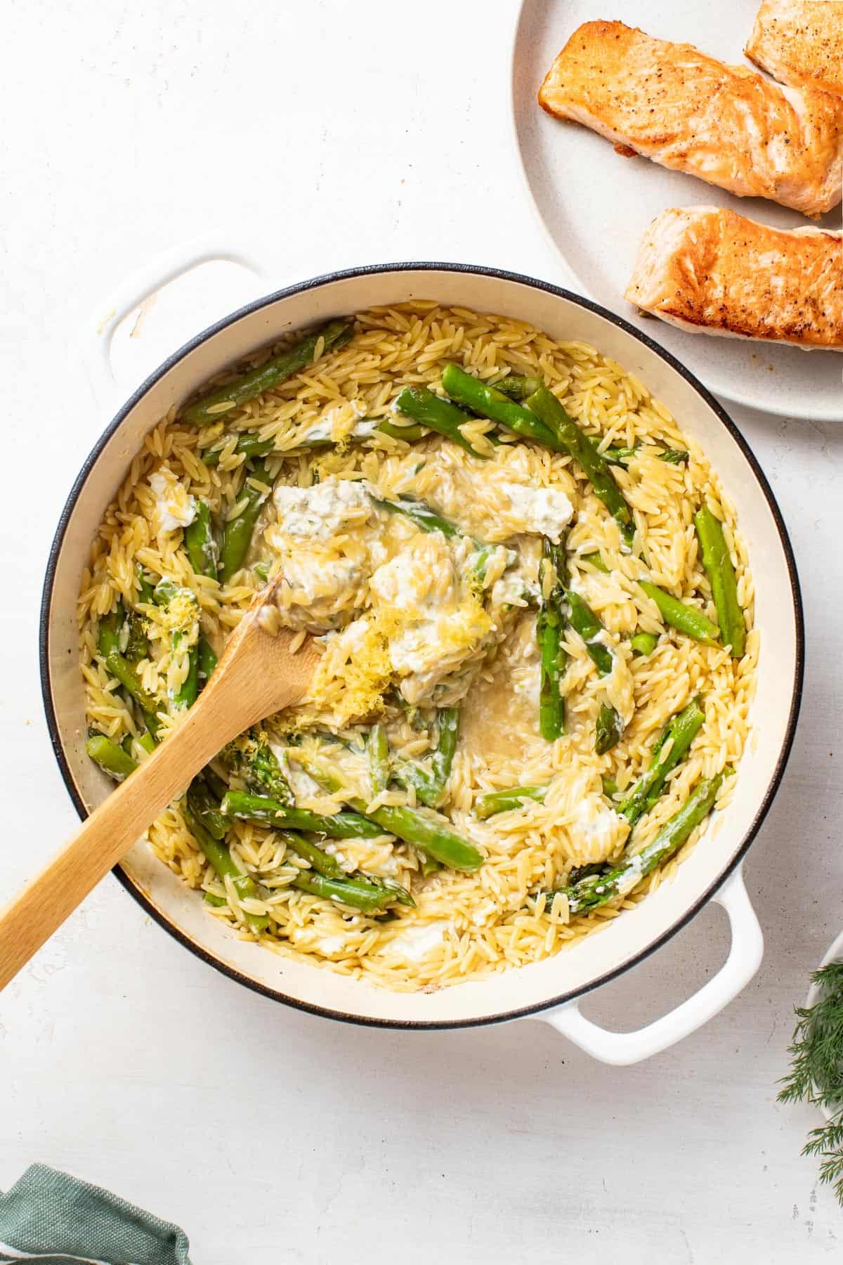 Stirring the orzo with a wood spoon after cooking.
