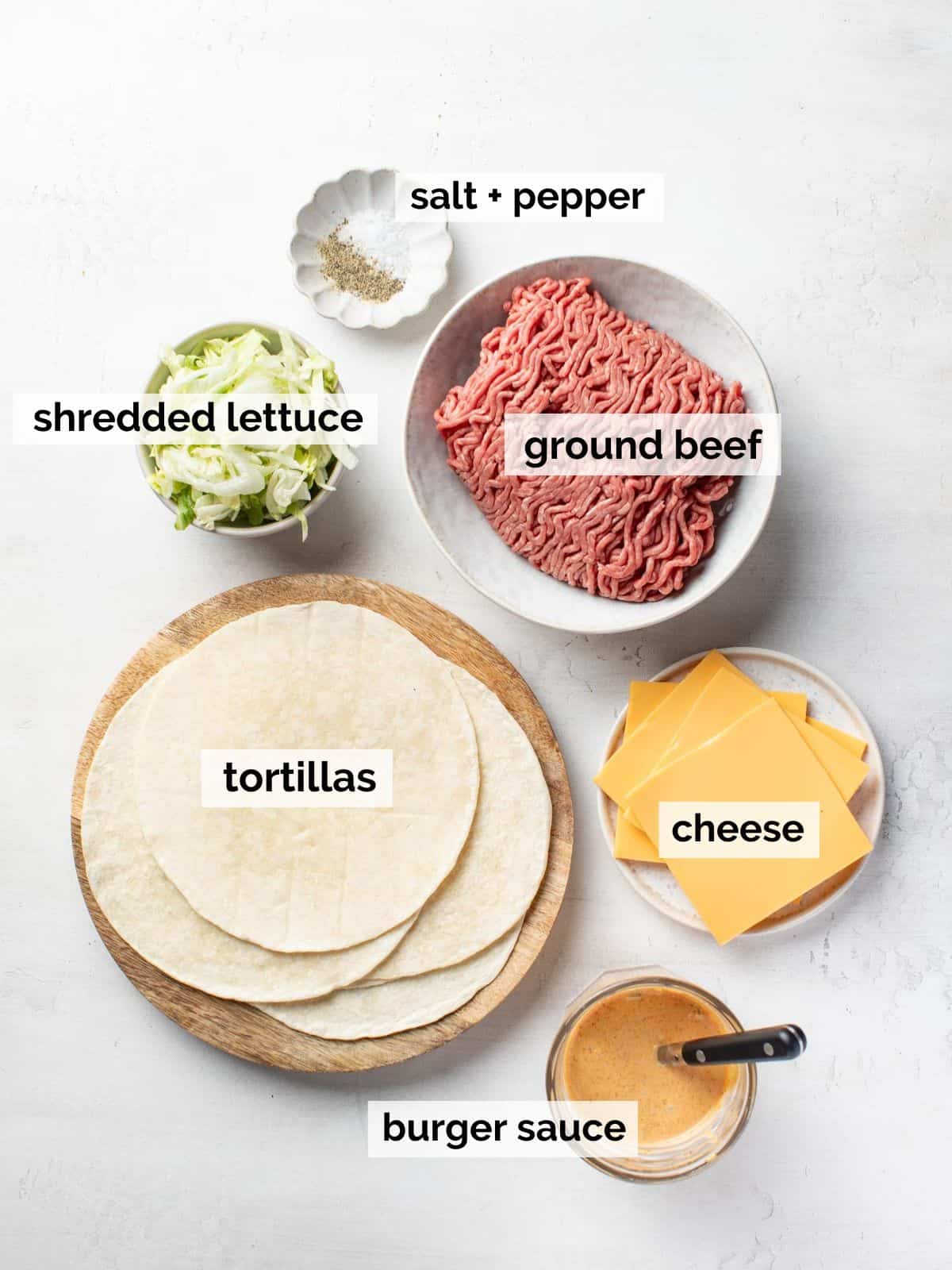 Ingredients for smash burger tacos on a white background.