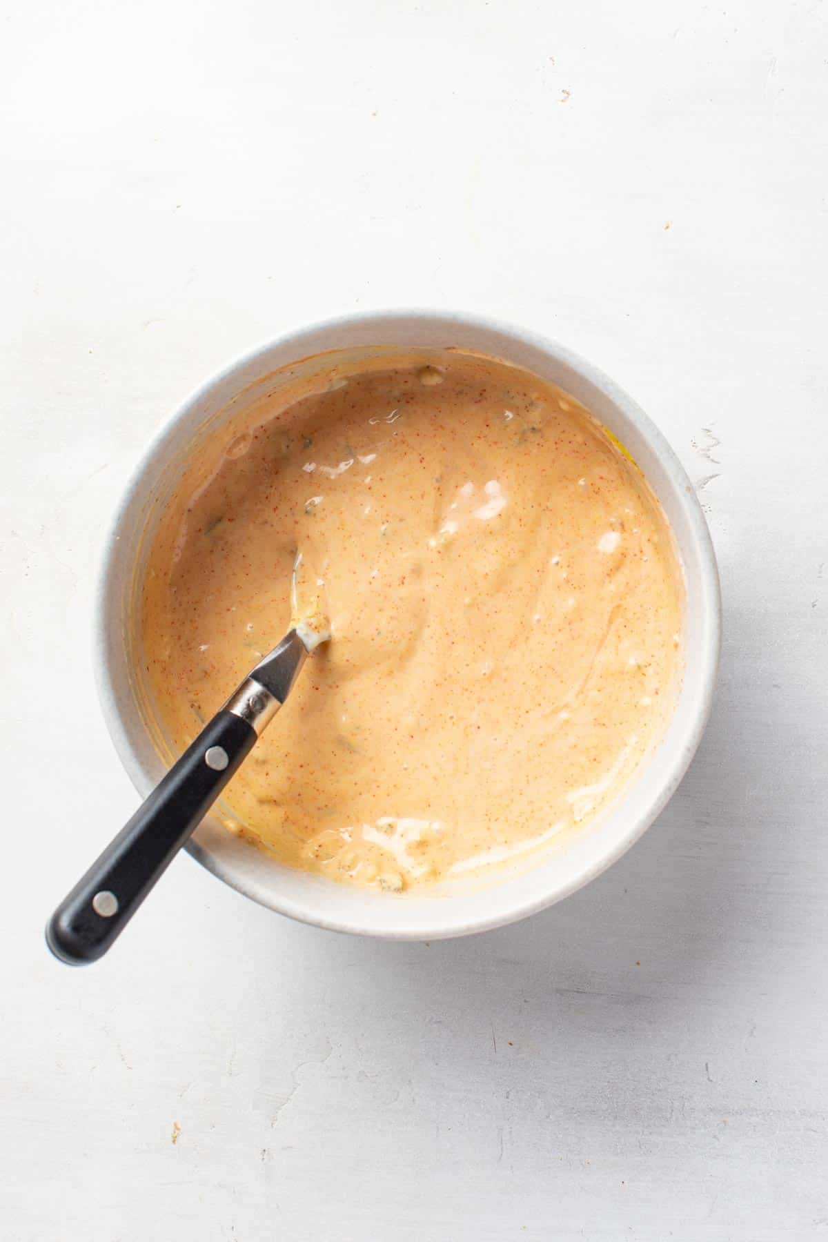 Whisking the ingredients for a big mac burger sauce in a bowl.