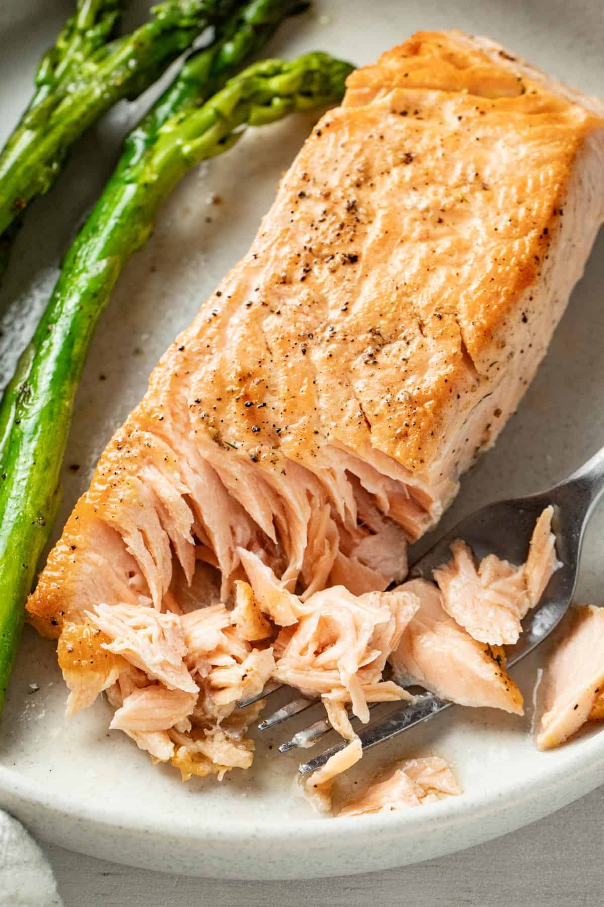 Golden brown fried salmon flaked with a fork.