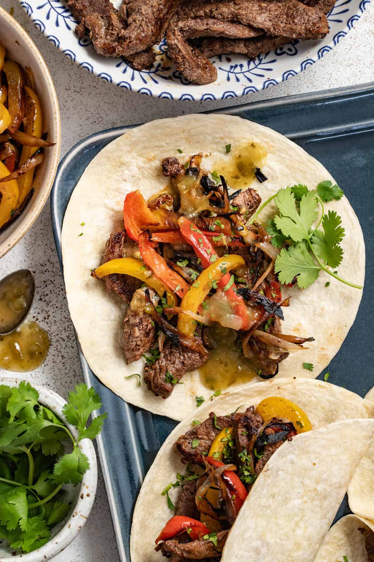 A steak fajita filled with red and yellow bell peppers.